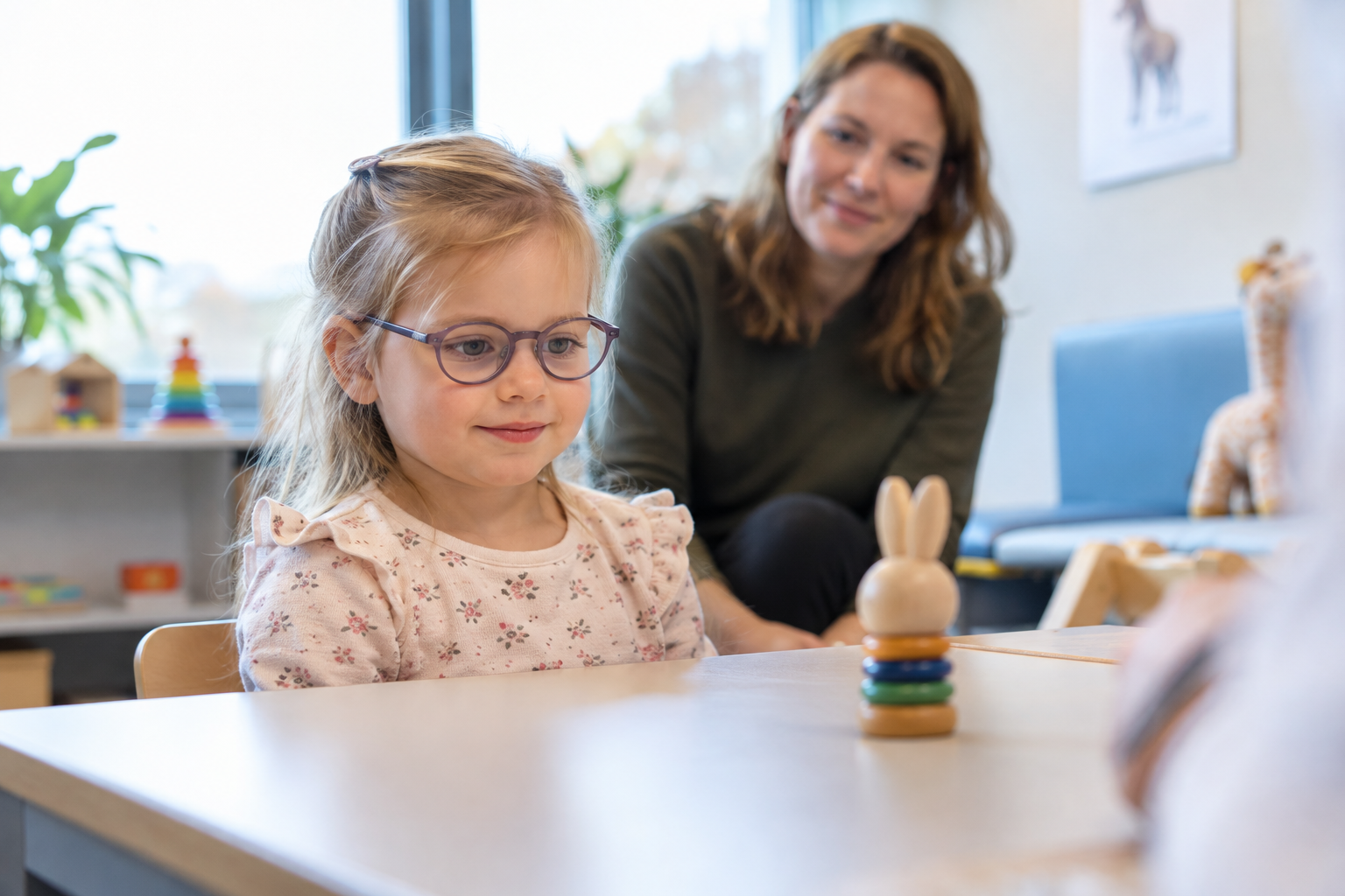 Kind met bril kijkt naar speelgoed
